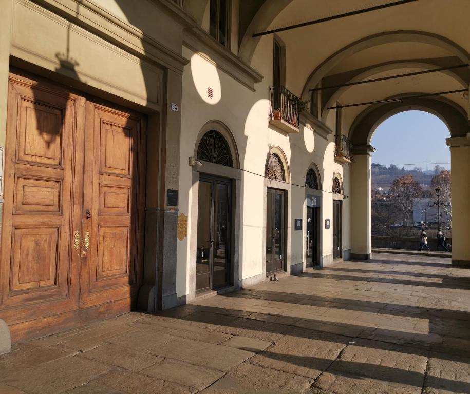 alejka z dużymi drewnianymi drzwiami w budynku w obiekcie Jacuzzi Luxury Apartment in the Town Centre w Turynie