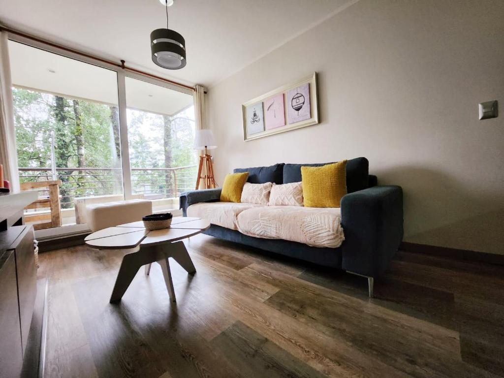 a living room with a couch and a table at Apartamento Camino Al Volcan in Pucón