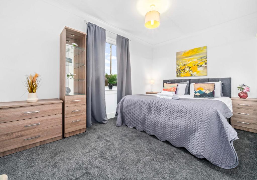 a bedroom with a bed and a large window at Broomfield Apartment by Klass Living Airdrie in Airdrie