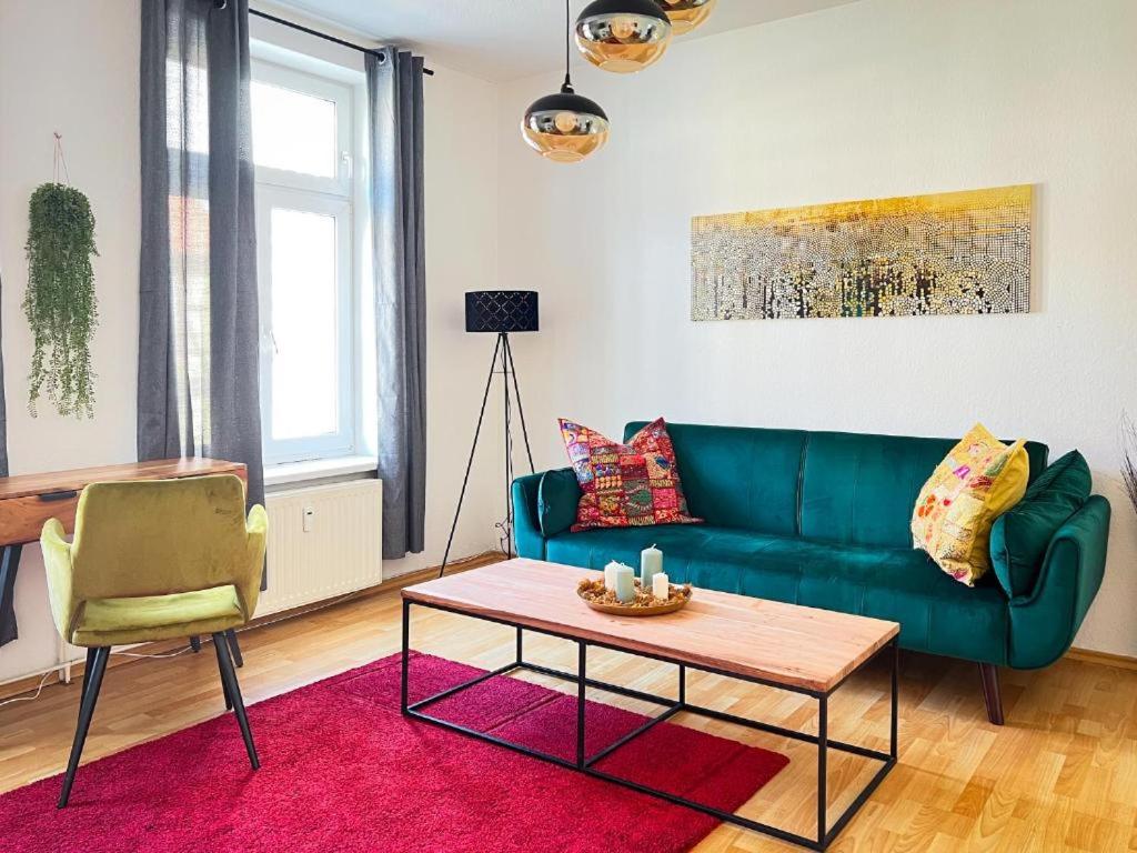 a living room with a green couch and a table at Homestayplus Schwerin in Schwerin
