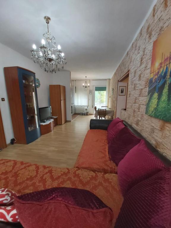 een woonkamer met een bank en een kroonluchter bij Appartamento Venezia in Marghera