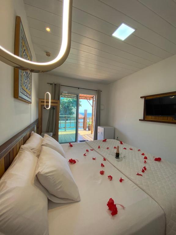 a bedroom with roses on a white bed at Pousada do Nativo in Fernando de Noronha