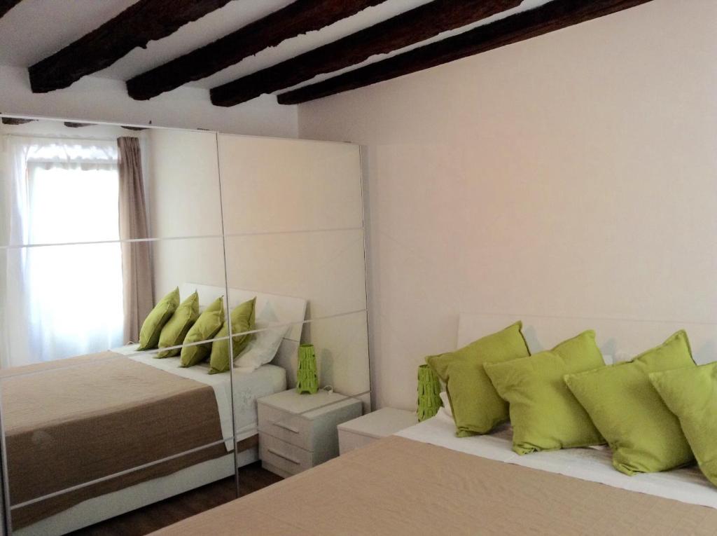 1 dormitorio con 2 camas y almohadas verdes en Nel Cuore Di Venezia, en Venecia