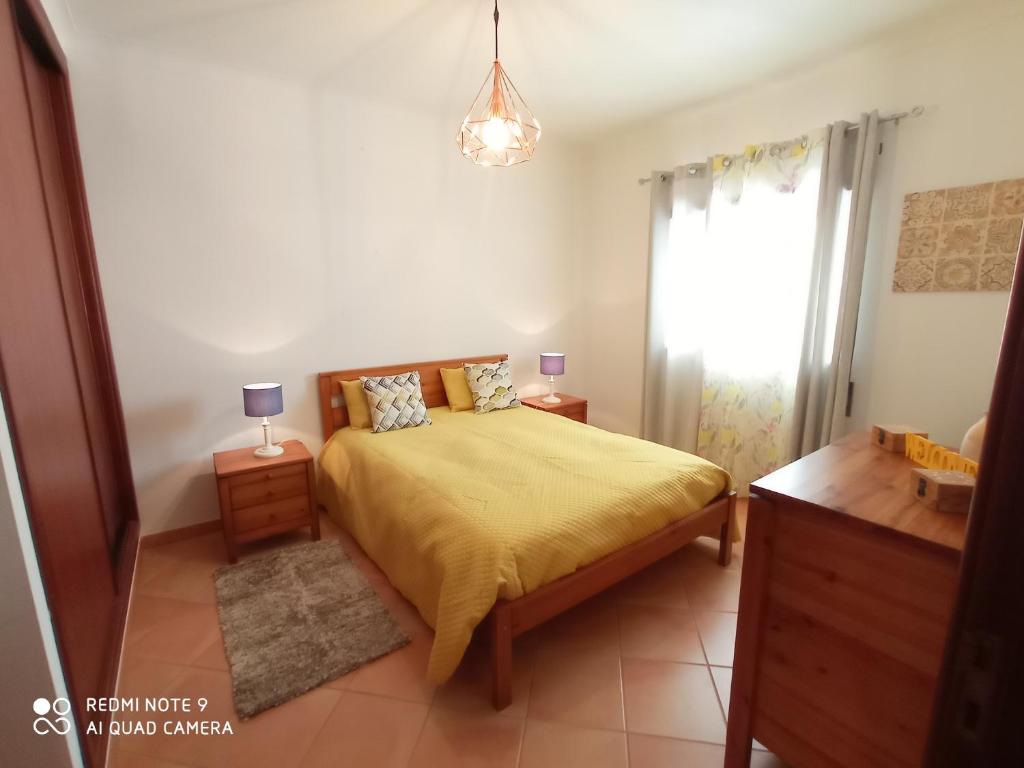 una camera con letto e copriletto giallo di Beach House Haller ad Aljezur