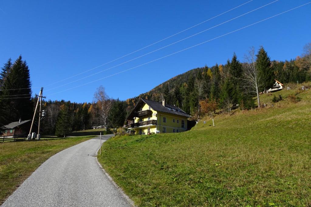 a house on a hill next to a road at Alpenloft Theresia in Ferlach