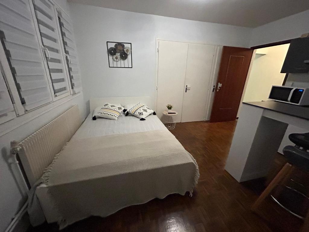 une chambre avec un lit avec deux oreillers dessus dans l'établissement Studio Rue De Dijon, à La Fillotte