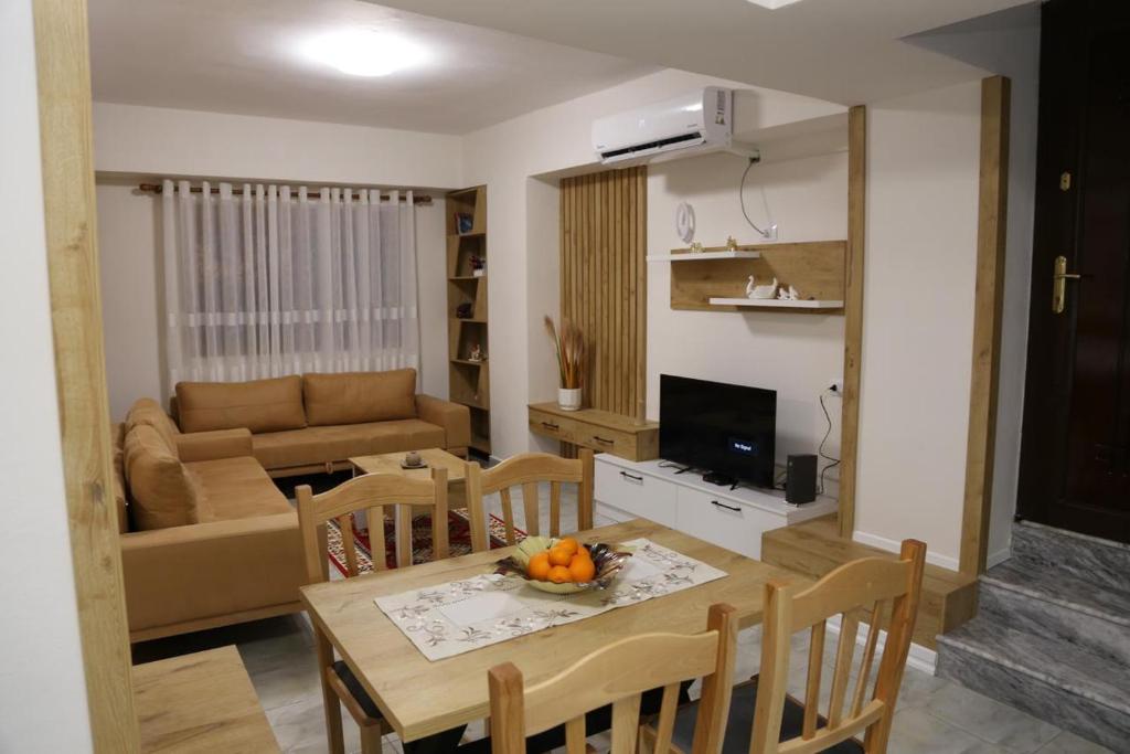 een keuken en een woonkamer met een tafel en stoelen bij Modern Marvel Apartment in Krujë