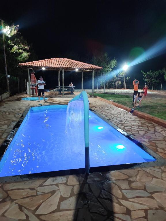 een waterglijbaan in een zwembad 's nachts bij Sitio Cheiro Do Campo in Jaboticatubas