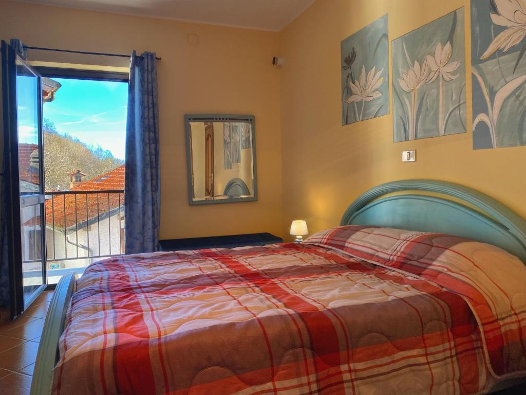 a bedroom with a bed and a view of a balcony at Sunrise Inn & Spa in Pessinetto