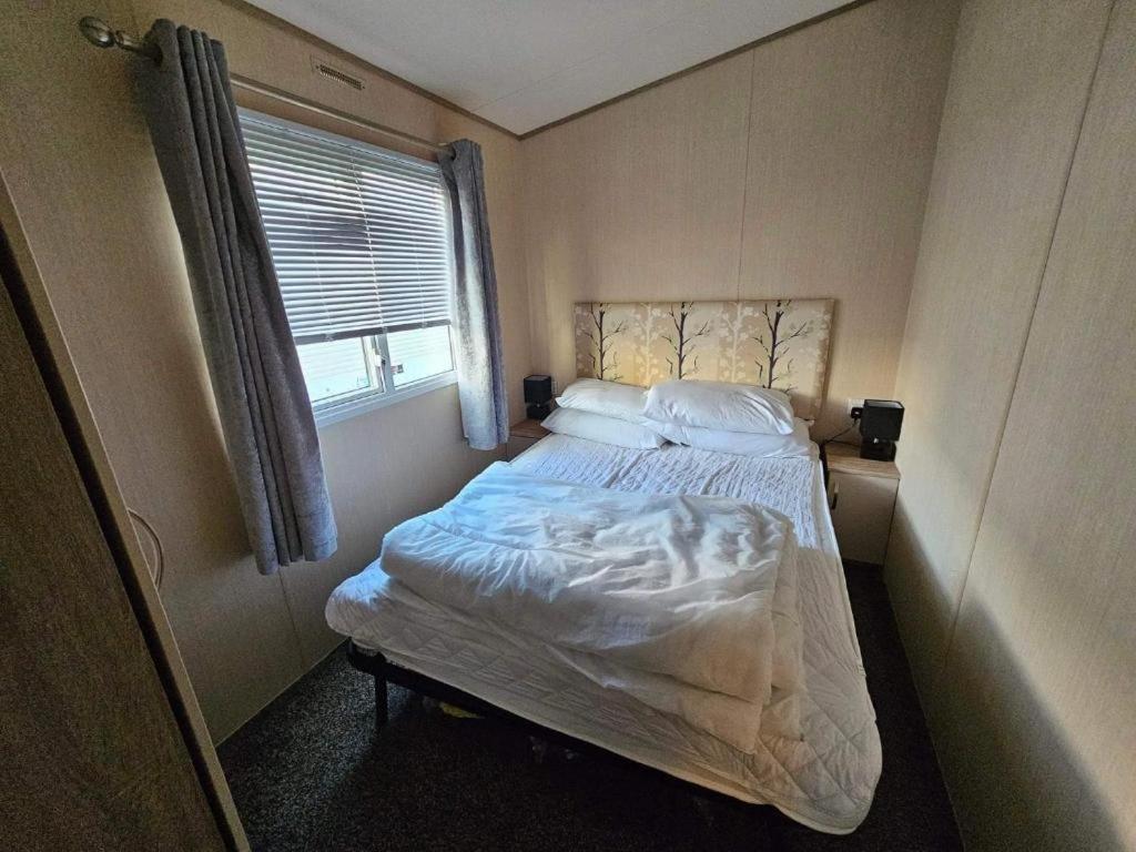 a bedroom with a bed in a room with a window at Jayden in Rhyl