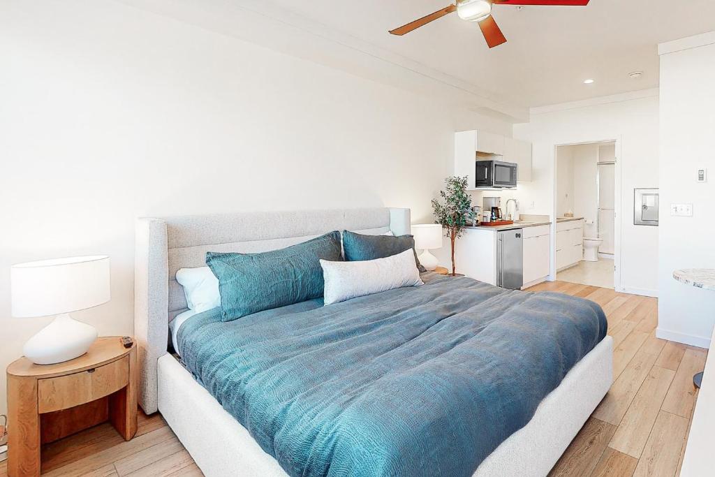 een slaapkamer met een groot bed en een blauwe deken bij Mellow on Meadow Mile 2B in Fraser