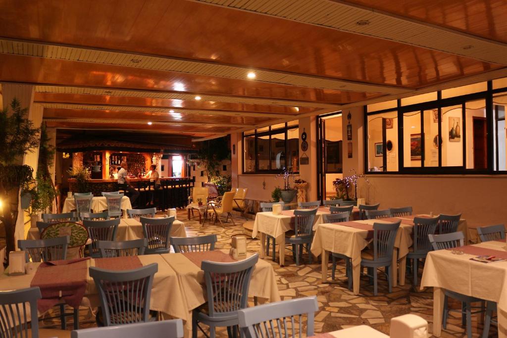 um restaurante com mesas e cadeiras e um bar em Arya Hotel em Cesme