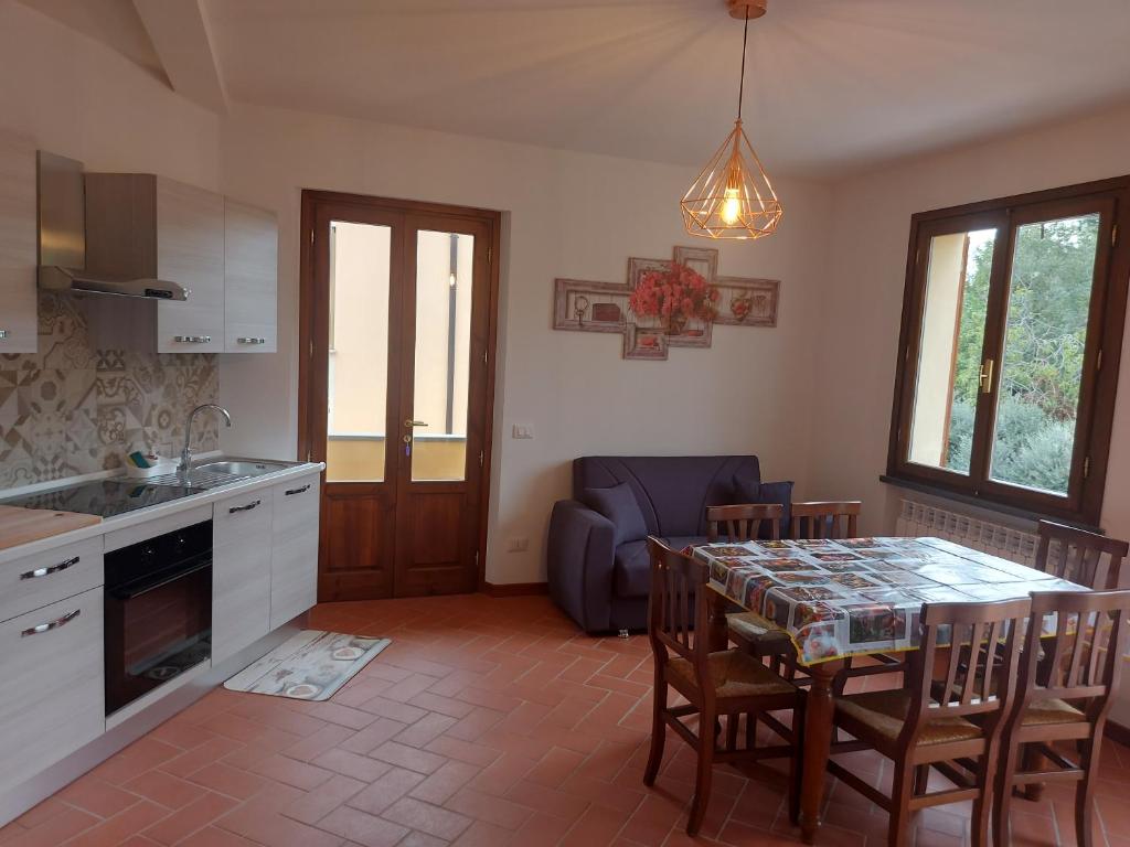een keuken en eetkamer met een tafel en stoelen bij San Rocco Appartamenti 2 - Appartamento IL CASTAGNO in Asciano Pisano