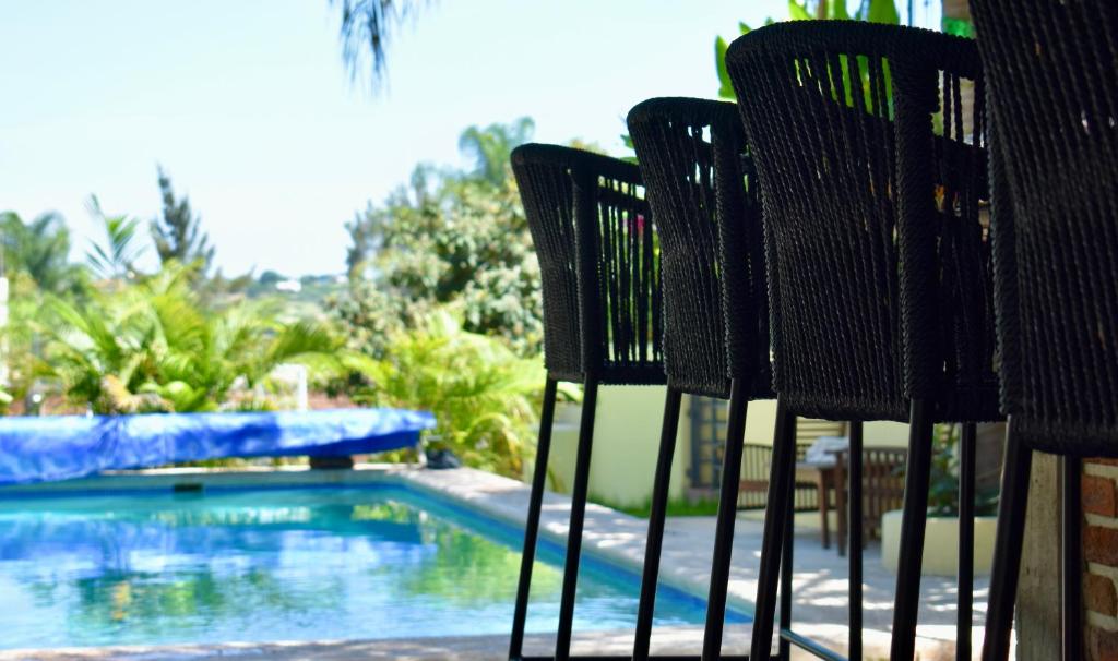 dwa krzesła siedzące obok basenu w obiekcie Villas de Morenos w mieście Buenavista
