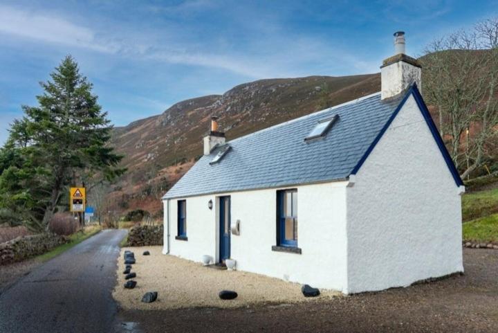 a small white house on the side of a road at 176 Marrell in Helmsdale