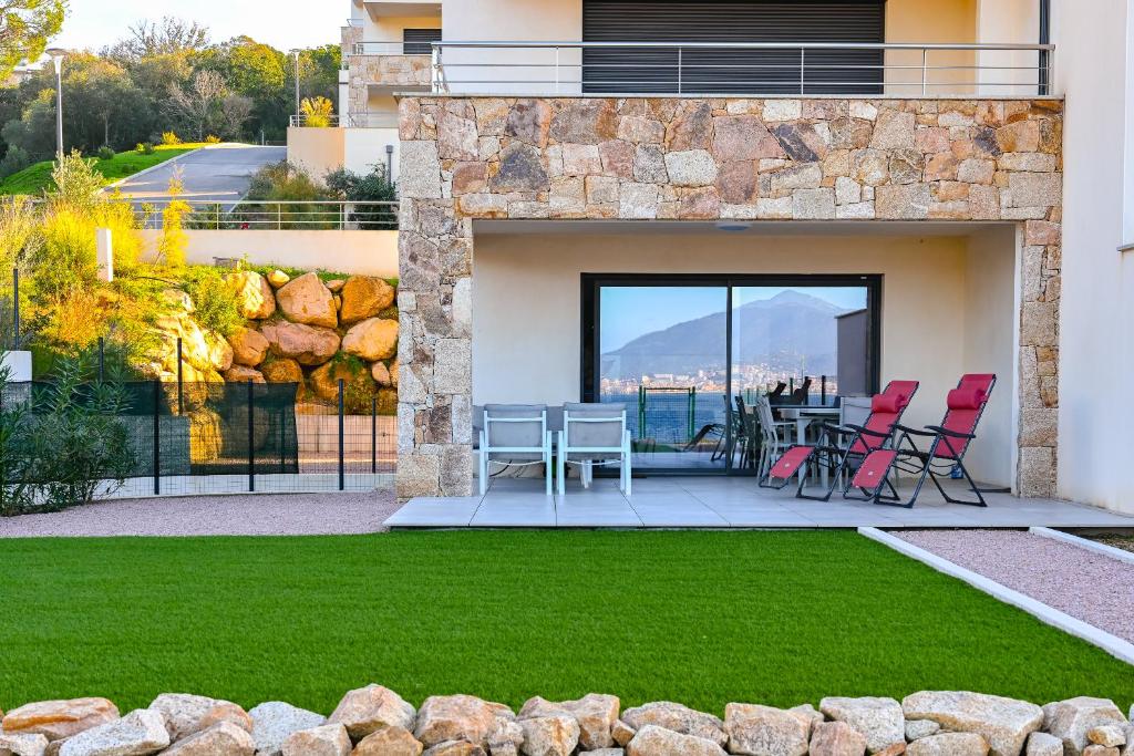 un patio avec des chaises et une table sur un balcon dans l'établissement T3 vue mer 100 m2 de jardin 'D', à Pietrosella