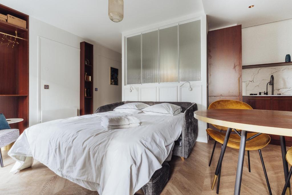 a bedroom with a large bed and a table at Luxueux Appartement proche Disneyland in Bussy-Saint-Georges