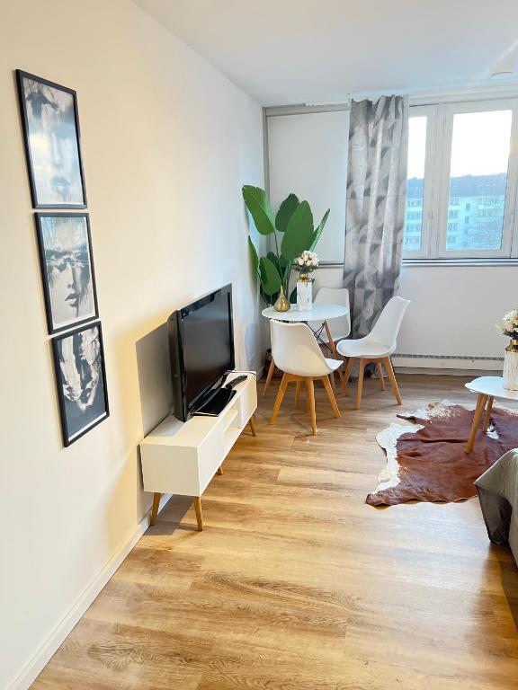 uma sala de estar com uma televisão e uma mesa em Kölner City Apartment direkt am Zentrum Nähe Hbf em Colônia