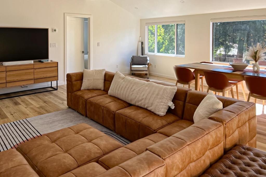 Sunridge Point في Pebble Beach: غرفة معيشة مع أريكة بنية وطاولة