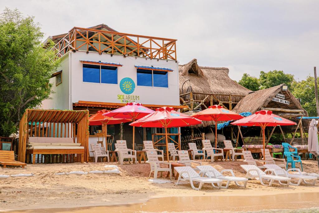 a group of chairs and umbrellas on a beach at Solarium Beach Club in Playa Blanca