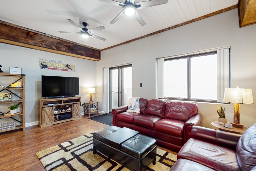 ein Wohnzimmer mit Ledermöbeln und einem Flachbild-TV in der Unterkunft Paradise Peak Retreat in Sugar Mountain