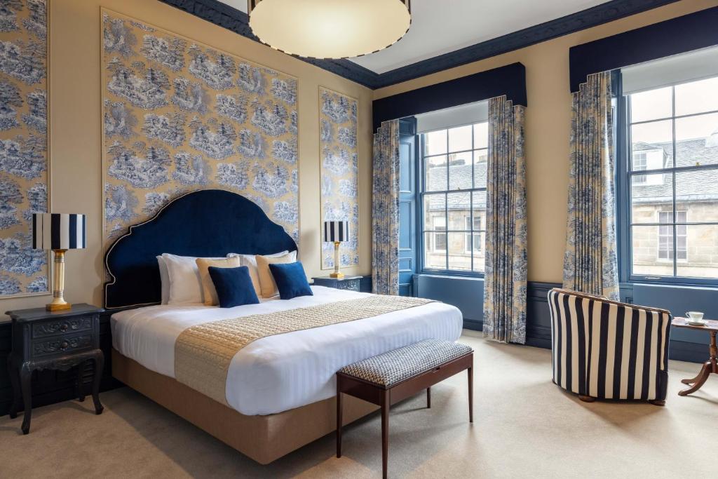 Cet appartement comprend une chambre dotée d'un grand lit, de murs bleus et de fenêtres. dans l'établissement Eleven Stafford Street Townhouse, à Édimbourg
