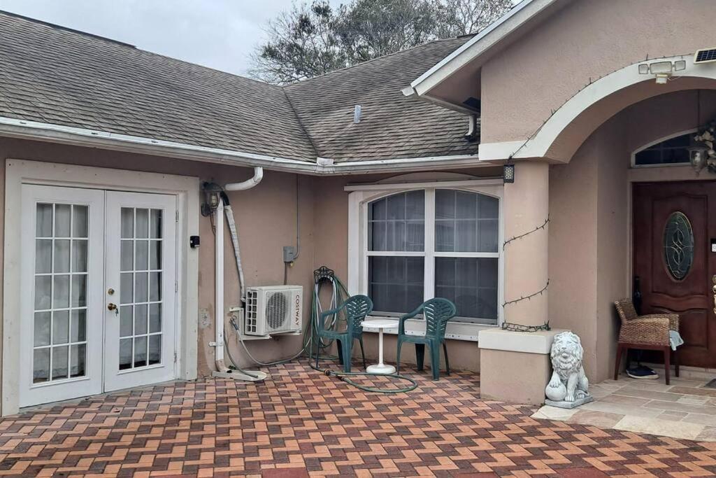 ein Haus mit einer Terrasse mit 2 Stühlen und einem Tisch in der Unterkunft Brand new studio apartment in Vero Beach