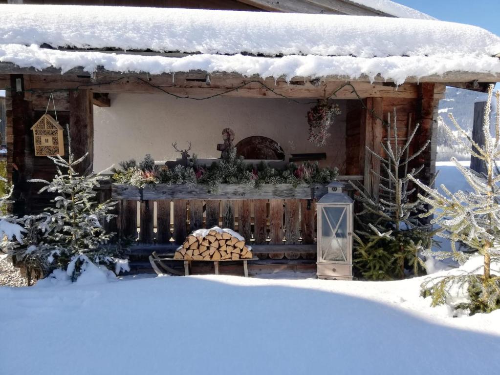 ein Haus mit einem Kamin im Schnee in der Unterkunft Mitterschützinghof in Saalfelden am Steinernen Meer