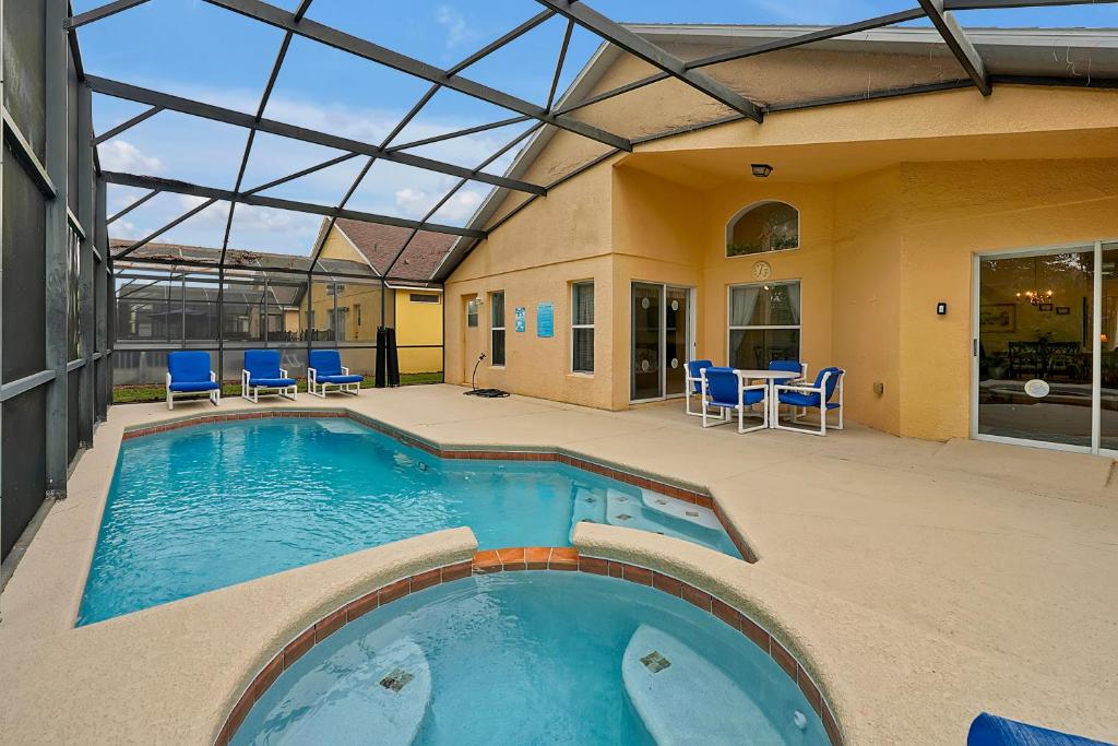 una piscina con sedie blu e una casa di Castaway Getaway - 4 bed - close to Disney a Kissimmee