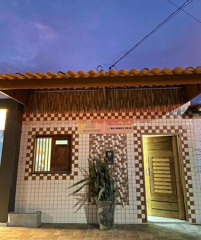 uma pequena casa de tijolos com uma porta e uma planta em Aconchego de Maria em Piranhas