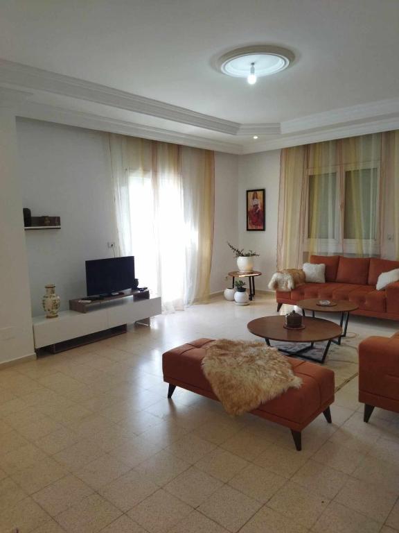 a living room with a couch and a tv at BENSASSI Urban Escape Premium in La Marsa