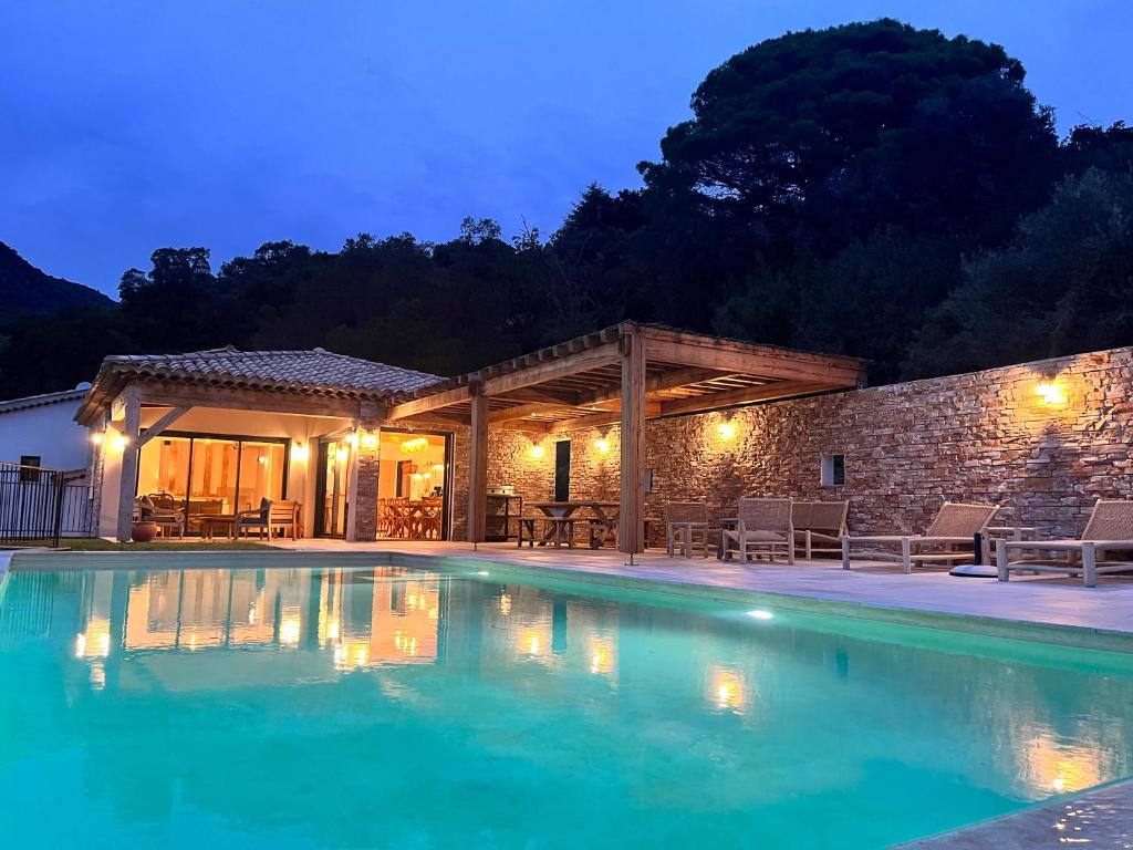 une villa avec une piscine la nuit dans l'établissement La Maison de la Genette - 5 étoiles, à Cavalaire-sur-Mer