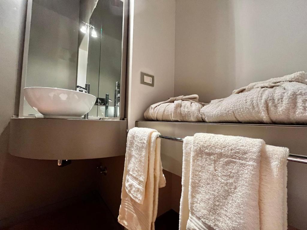 a bathroom with a sink and towels on a rack at Serravalle Castle Apartment in Serravalle