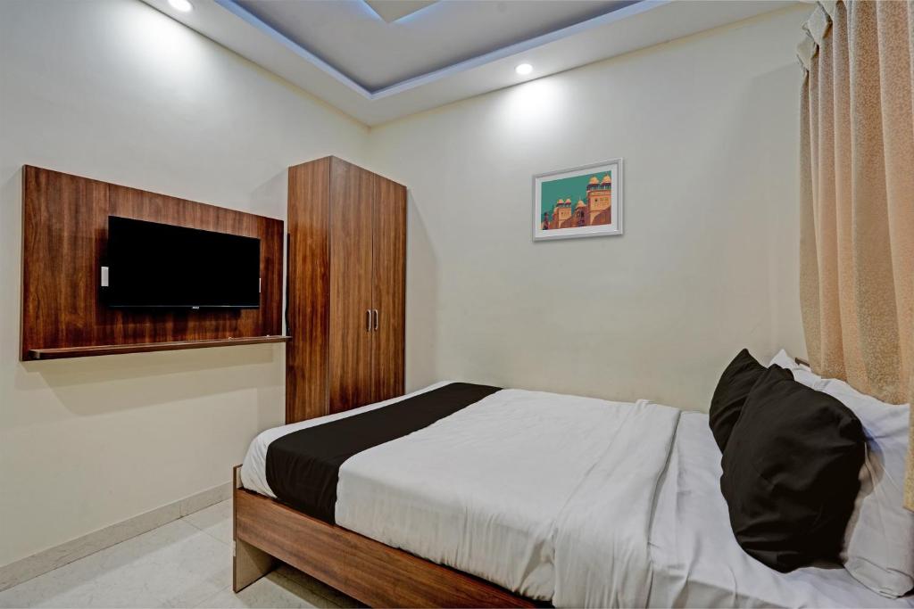 a bedroom with a bed and a flat screen tv at Collection O Cka Boarding And Lodging in Yelahanka