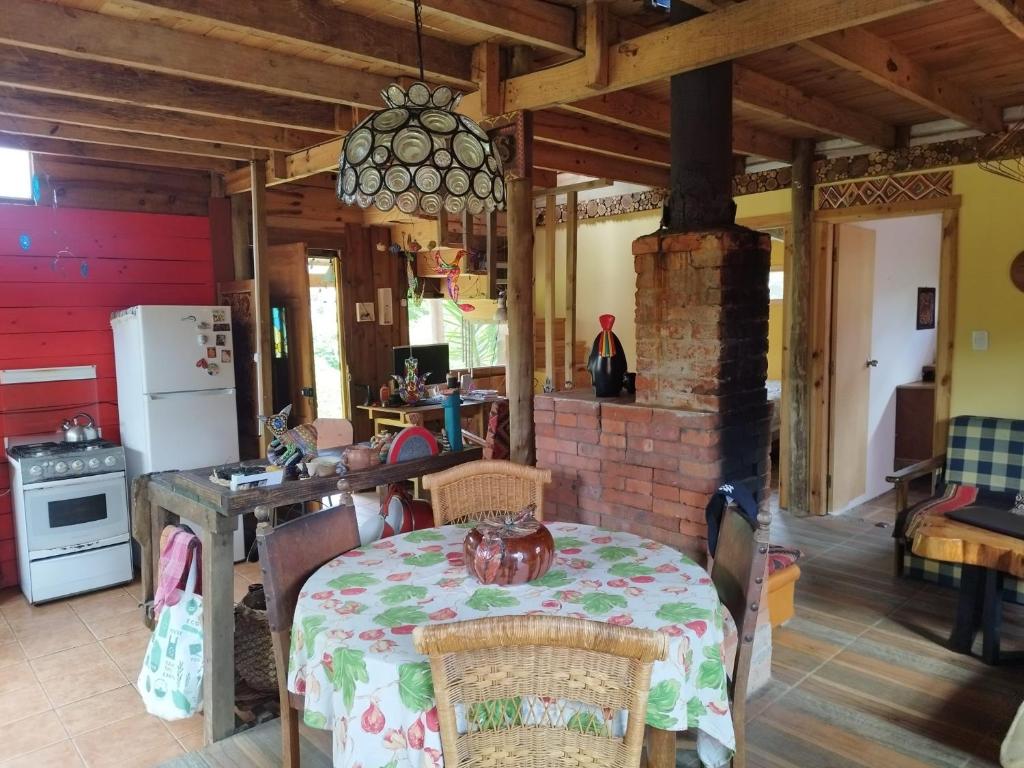 eine Küche mit einem Tisch und einem gemauerten Kamin in der Unterkunft Cabaña de Alejandro in La Paloma
