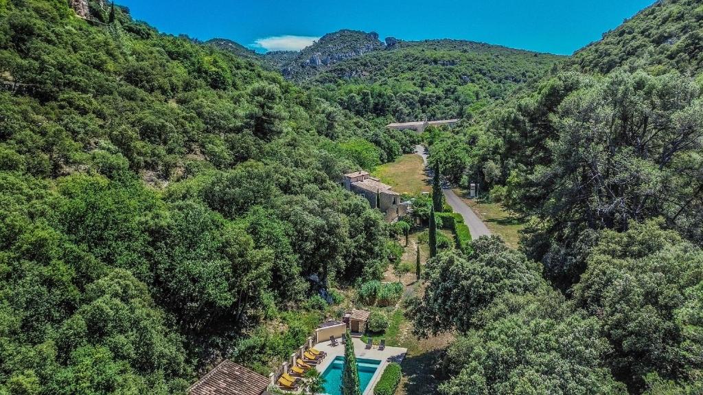 une vue aérienne sur une montagne avec une piscine et une route dans l'établissement La Bergerie Pradel, à Le Beaucet