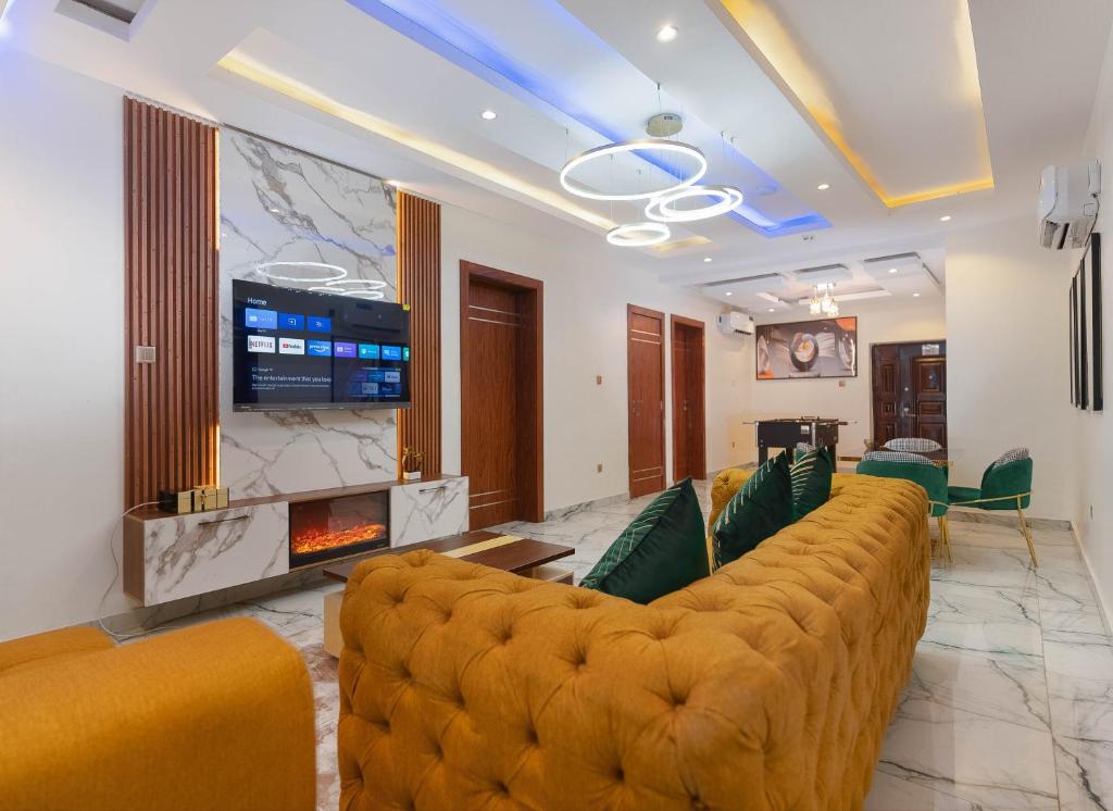 - un salon avec un grand canapé et une cheminée dans l'établissement God's Touch Apartments Remi Fani Kayode GRA. Ikeja, à Ikeja