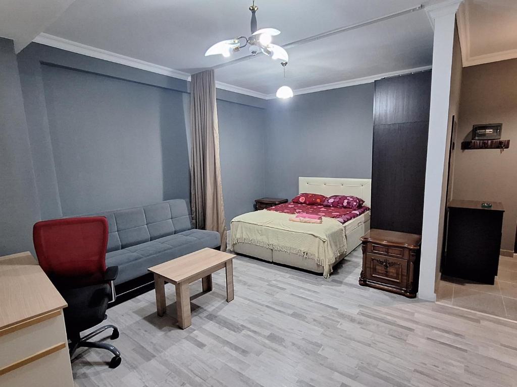 a bedroom with a bed and a couch and a table at Next Level in Poti
