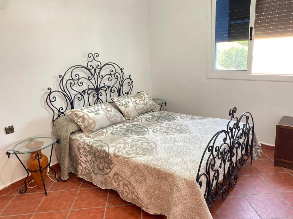 a bedroom with a bed with a metal headboard at Awechtam house in Aouchtame