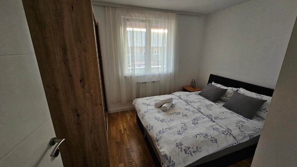 1 dormitorio con cama y ventana en Stan na dan-Apartman Mia, en Lukavica