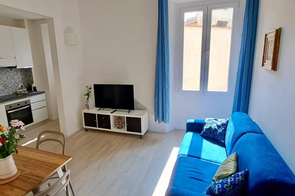 uma sala de estar com um sofá azul e uma televisão em Le case di Cate e Max - Luna em Florença