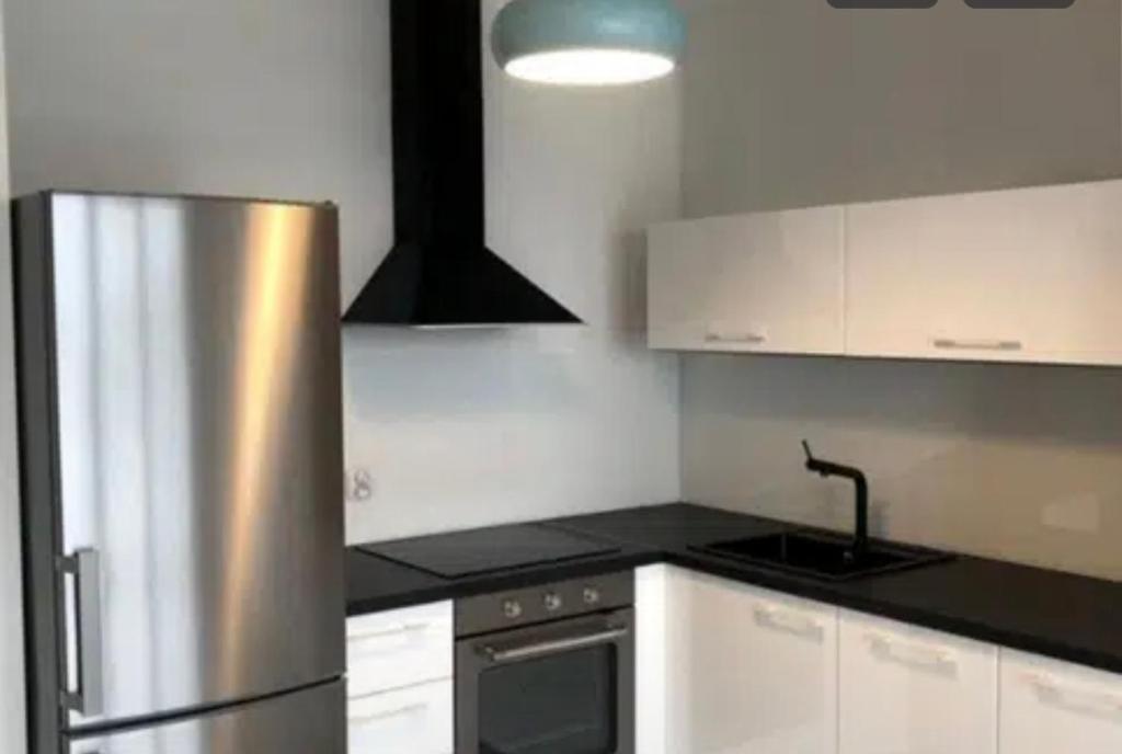 uma cozinha com um frigorífico de aço inoxidável e armários brancos em VIP apart 537 em Tsqnetʼi