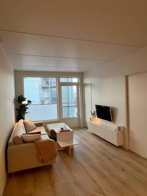 uma sala de estar com um sofá e uma televisão em Modern apartment nearby city centrum em Tromsø