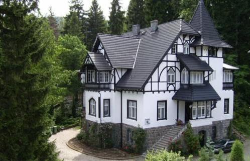 a large white house with a black roof at Willa Rosa in Karpacz