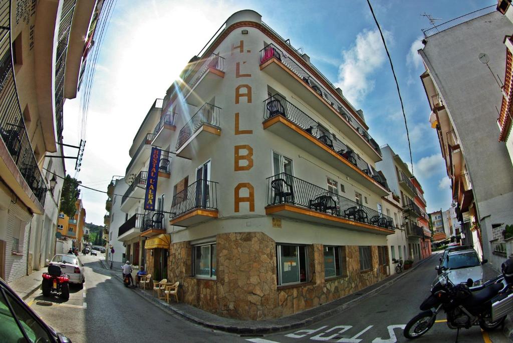 a building with a sign on the side of it at Hostal L'Alba in Tossa de Mar