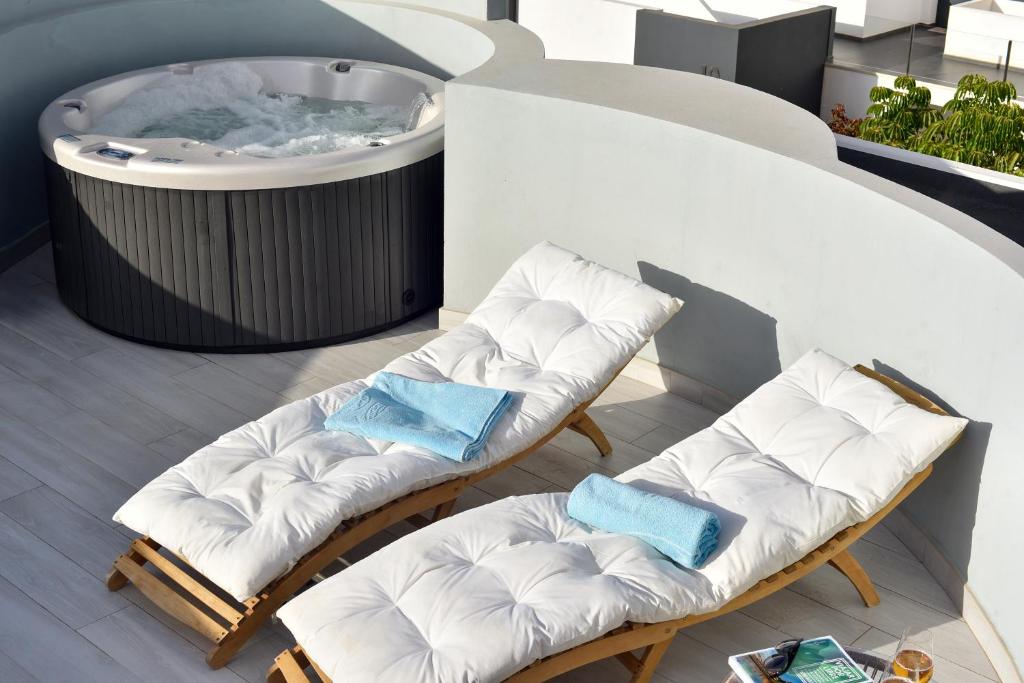 2 Stühle und ein Whirlpool auf dem Balkon in der Unterkunft Luxury aparment in casilla de costa with Jacuzzi- Follow the sun in La Oliva