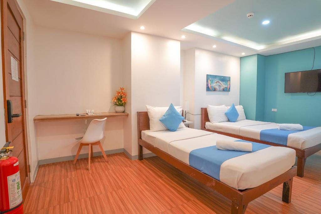 um quarto de hotel com duas camas e uma secretária em Arzo Hotel Makati Premier em Manila