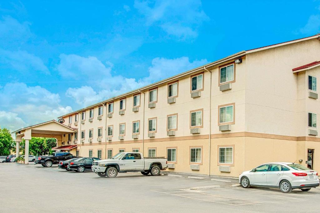 a large building with cars parked in a parking lot at Super 8 by Wyndham San Antonio/Fiesta in San Antonio