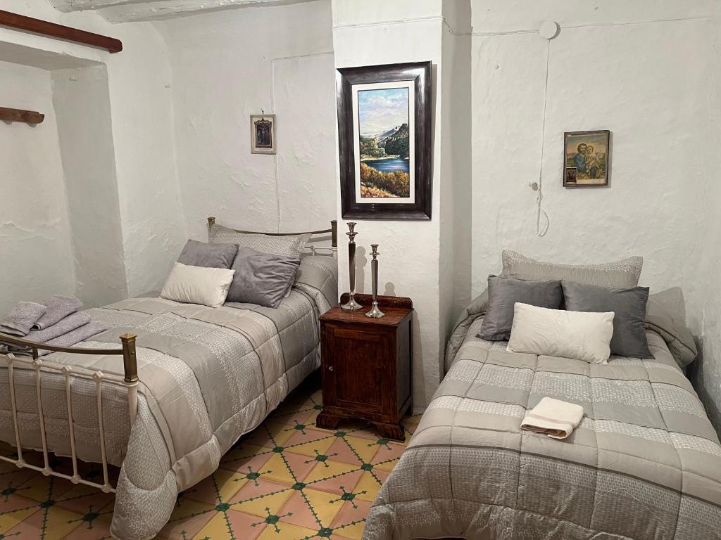 1 dormitorio con 2 camas y mesa de madera en Casa del nano, en Valdepeñas de Jaén