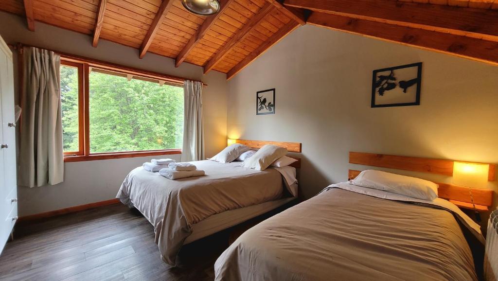 a bedroom with two beds and a window in it at Bellavista in Villa La Angostura